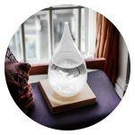 Stormglas in de vorm van een druppel op houten voet