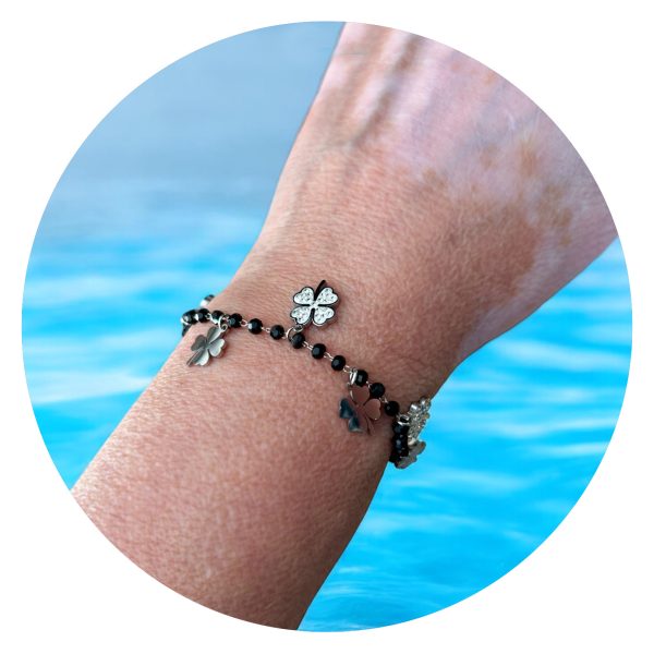 Armband met zwarte facetkralen en klavertjes