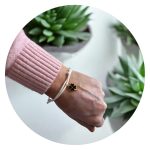 Veterarmband wit met zwart klavertje goud