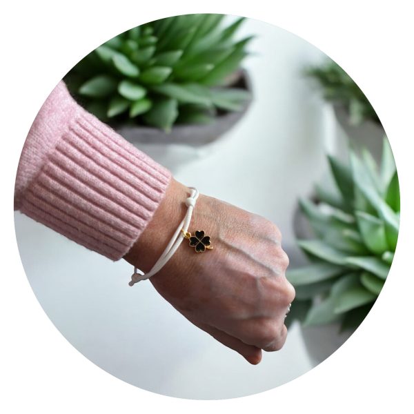 Veterarmband wit met zwart klavertje goud