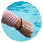 Veterarmband zwart met wit klavertje goud