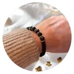 Armband platte zwarte kraaltjes en gouden ringetjes