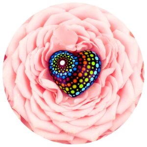 houten hartje met dot painting op een achtergrond van roze bloemblaadjes.